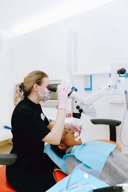 A dentist using advanced equipment during a dental exam in a clinic.